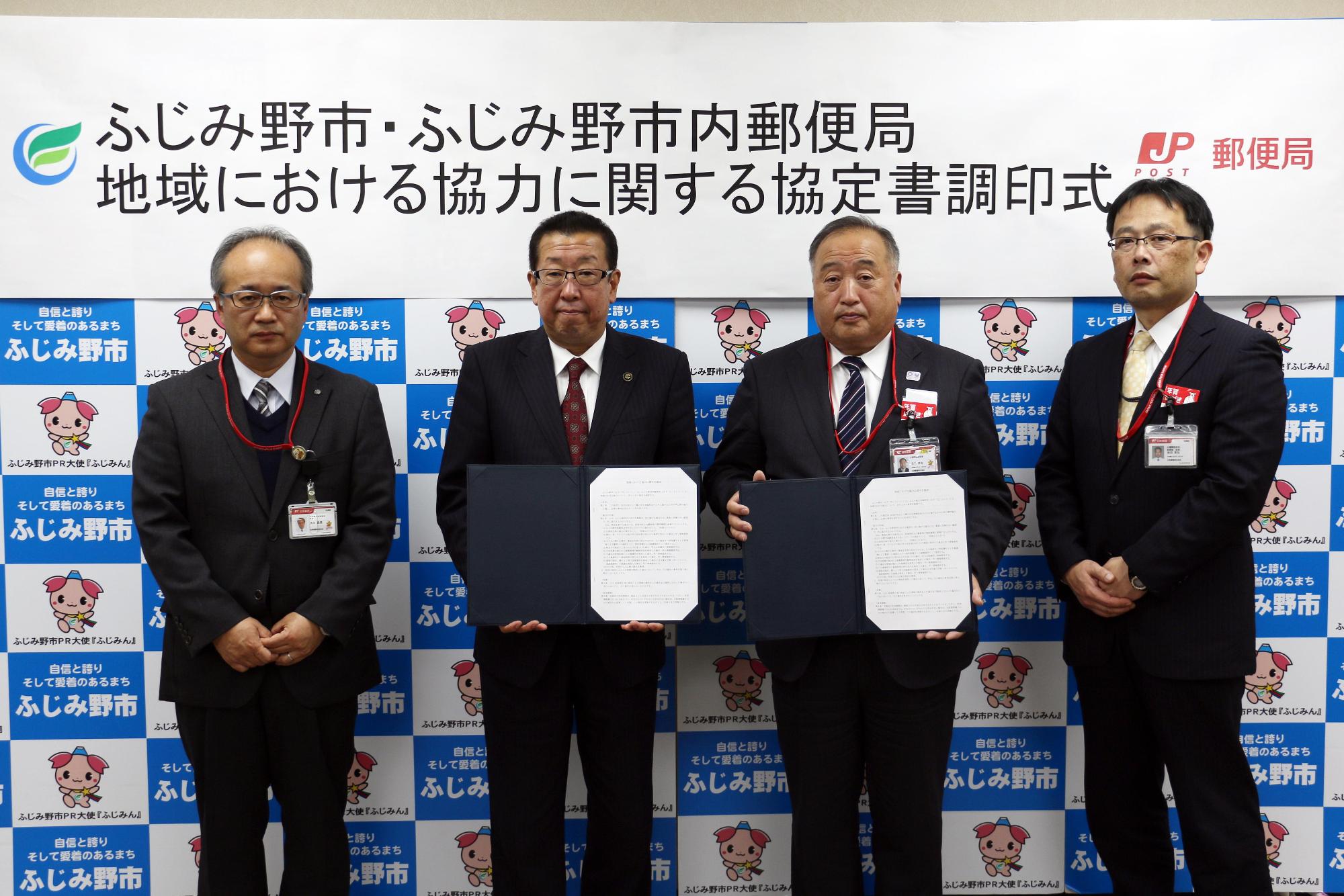 郵便局の方3名と市長が協定書を持って記念撮影をしている写真
