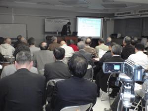 基調講演会で会議室に多くの方が集まり講演を聞いている写真
