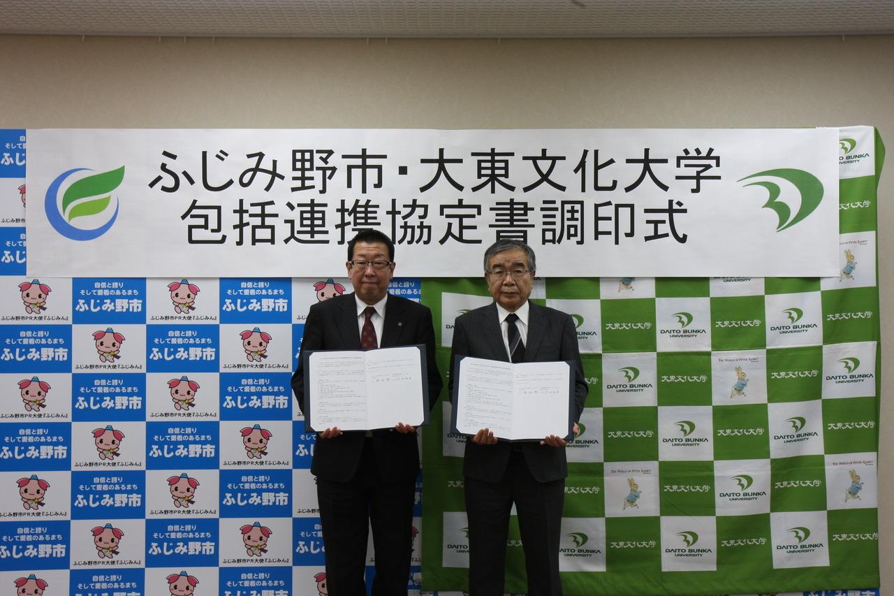市長と大東文化大学代表の方が調印書を持って記念撮影をしている写真