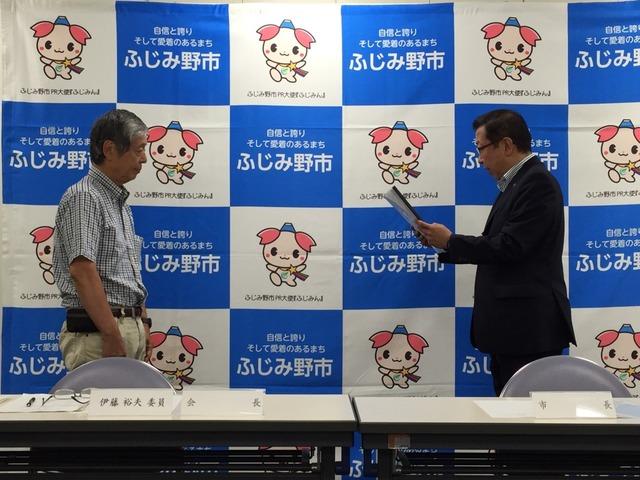 市長が会長の伊藤様に諮問を読み上げている様子の写真