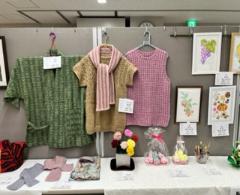 作品のコーナーが設けられており、ボードや机に手作りの洋服や小物などの作品が置かれている写真