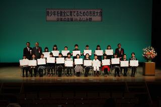 少年の主張inふじみ野にて発表者が賞状を手に持ち舞台で記念撮影している写真