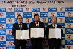 市長とふじみ野市町会・自治会連合会の関係者の男性と、公益社団法人埼玉県宅地建物取引業協会埼玉西部支部の関係者の男性が協定書を手に持って写っている写真