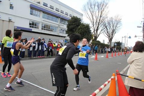 中継所でランナー達がタスキをつないでいる写真