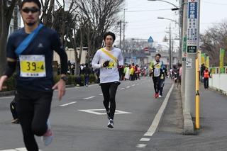 沿道にいる人々の声援を受けながら走っているランナー達の写真