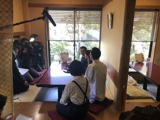料理人とスタッフと市長が和室の料亭にすわり撮影をしている所を横から写した写真