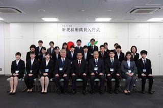 「平成31年度新規採用職員入庁式」と書かれている横断幕の前で、21名の新規採用職員と市長、関係者の方々が整列して写っている集合写真