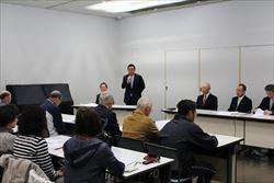 着席する定例総会の参加者の前で、マイクをもって話をする市長の写真