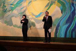 手話通訳の女性の横に立ち、話をする市長の写真