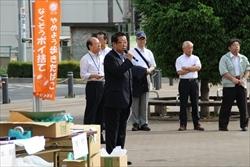 手前にはキャンペーンで配るチラシが段ボールの中に入って積まれており、その横で市長がマイクを持って話されている写真