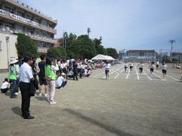 生徒達がゴールする場所でカメラを持ち撮影している人達を写した写真
