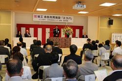 施工式の会場にて、来賓者が席に着き、紅白の横断幕が貼られている舞台の演台で市長が話しをしている写真