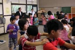 前の子供の肩に手をのせ、みんなで輪になり楽しんでいる様子を見ている市長の写真