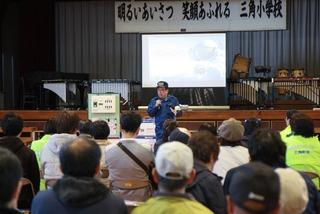 三角小学校で消防職員の人が前に立ち、参加者に話をしている写真