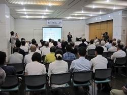 タウンミーティングにて参加者の前で挨拶する市長の写真