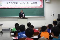 子ども大学ふじみの入学式にて黒板の前で挨拶する市長の写真