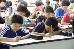 生徒が机で書き物をしている写真