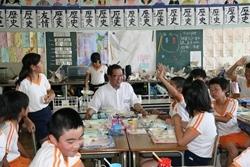 三角小学校にて生徒と一緒に給食を食べる市長の写真