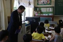 黄色いシャツを着た男の子と話す、市長の写真