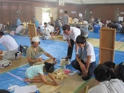 ものづくりくらぶの会場で、参加者の女の子が木に印を付けているのを市長たちが見ている写真