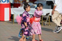 浴衣を着た女の子2名が歩いている様子を横から撮影した写真