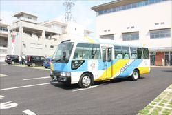水色や黄色で塗装されたバス1台が駐車場に停まっている写真