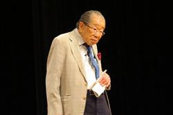 日野原 重明さんが左手に紙を持ち立っている写真