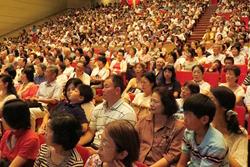 講演会の観客席に着席している、満席状態の老若男女の写真