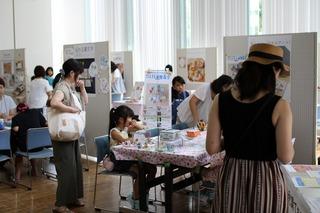 色々なブースが設けられたスペースで、ワークショップに参加する小学生の女の子の写真