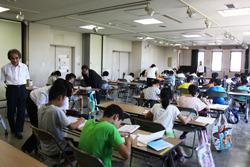 生徒たちが、それぞれ学習したり、横に立ち、教えている指導員の写真