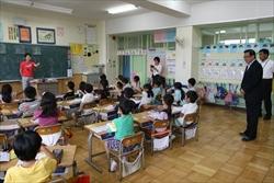 三角小学校の授業の様子を後ろに立ち、見学する市長の写真