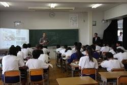 着席した生徒と、前に立つ男性の横に立つ市長の写真