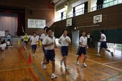 体操服姿で体育館を走る、中学生の生徒の写真