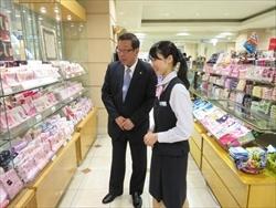 派遣職員から株式会社丸広百貨店のハンカチコーナーに案内される市長の写真