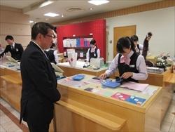 株式会社丸広百貨店のレジ対応をする派遣職員の様子を見学する市長の写真