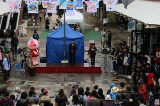 イベント会場に作られた特設ステージ上で挨拶をしている市長の写真
