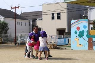 園庭で数名の園児と遊んでいる市長の写真