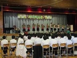 ふれあい西中祭のステージで演奏が行われている吹奏楽の演奏を見ている小学生たちの写真