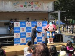 環境フェアのステージで市長より女の子が表彰されている写真