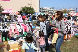 環境フェアの会場でフリーマーケットに出展されている洋服を見ている親子連れの写真