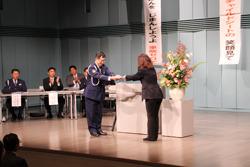 交通安全表彰式で女性が表彰されている写真