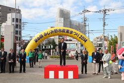 第6回 ふじみ野市産業まつり2014と書かれてバルーンの前で、市長が紅白の壇上に上がって話をしている写真
