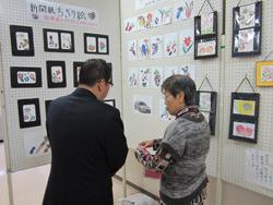 飾られたちぎり絵の前で話をする市長と女性の写真