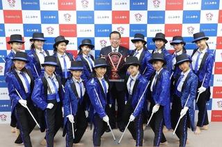 市長を中心にして、黒いハットを被りお揃いの衣装のヴァイオレットの皆さんとの集合写真