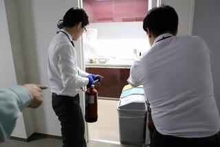 消防訓練が行われており、火災現場に向かって消火器を向けている写真