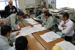 職員の方々が机に資料を広げて、本庁舎工事の進行状況を市長に説明をしている写真