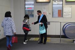 ごみポイ捨て防止・路上喫煙防止キャンペーンで、市長が駅のホームに入っていく女性にキャンペーンのチラシを手渡ししている写真