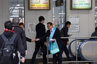 エスカレーターに乗る人達にキャンペーンのティッシュを配っている市長の写真