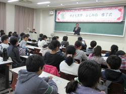 「子ども大学ふじみの」の修了式で、市長が壇上に立って、参加者の子ども達に話をしている写真