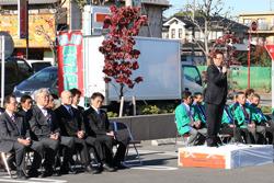 秋の収穫祭で、壇上で市長がマイクを持って話をしており、壇上の両側には関係者の方々が並んだパイプ椅子に座って、市長の話を聞いている写真